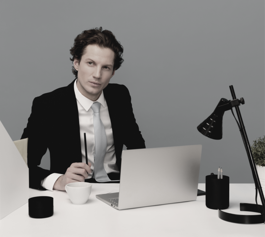 man in suit in front of laptop
