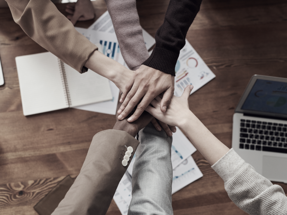 hands in the middle over laptop workspace